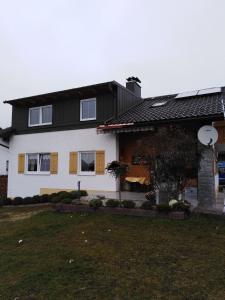 una casa blanca con techo negro y patio en Ferienwohnung für 5 Personen ca 80 qm in Regen, Bayern Bayerischer Wald, en Regen