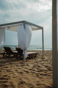a beach with chairs and an umbrella on the beach at Vala Mar Apartament in Draç