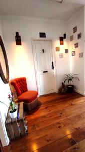 sala de estar con silla naranja y suelo de madera en DockApartment, en Vila Nova de Gaia