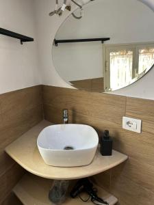 La salle de bains est pourvue d'un lavabo blanc et d'un miroir. dans l'établissement VILLA MULINO, à Naples