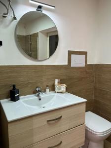 W łazience znajduje się umywalka, lustro i toaleta. w obiekcie VILLA MULINO w mieście Napoli