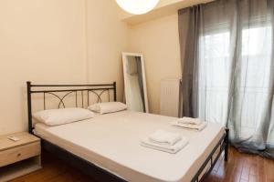 a bedroom with a bed with two towels on it at Luxury Pireas Stay New 2BR Urban Escape in Piraeus