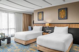 a hotel room with two beds and a table at Al Ghufran Safwah Hotel Makkah in Mecca +63 photos