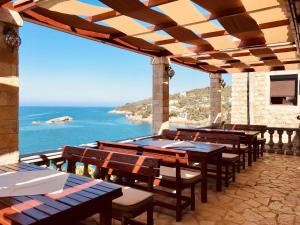 a patio with tables and chairs and a view of the ocean at Guest house Naser in Ulcinj