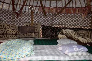 Un letto in una yurta con una tigre sopra di Yurt Stay Family Khansar a Nurota