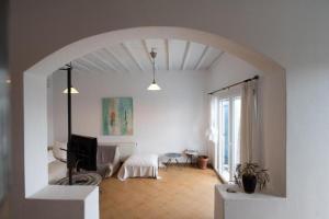 a living room with an archway with a tv in it at Dreamscape Cozy 3-Bedroom Mykonos Hideaway in Ano Mera