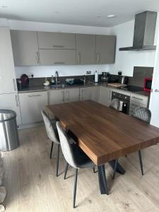 a kitchen with a wooden table and some chairs at Brand-new contemporary flat in Bermondsey in London