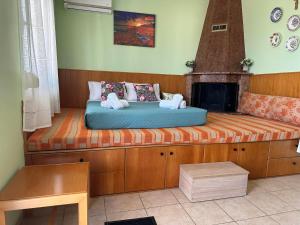 a bed sitting on a bench with a fireplace at GALINI STEGNA BEACH in Archangelos