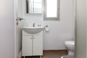een witte badkamer met een wastafel en een toilet bij Brand new 1 Bd Apt in Kolonaki in Athene