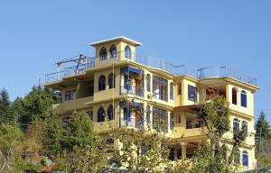 a yellow building with a balcony on top of it at Naldehra House in Shimla