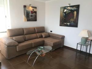 a living room with a couch and a glass table at Stunning views to the sea / City center Fuengirola in Fuengirola