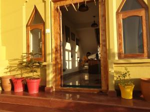 a hallway with potted plants and a person in the kitchen at Naldehra House in Shimla