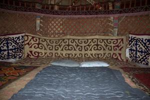 a large bed in a yurt with pillows at Yurt Stay Family Khansar in Nurota