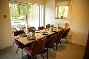 una sala da pranzo con tavolo e sedie in legno di Tussen Heide en Bos a Opglabbeek