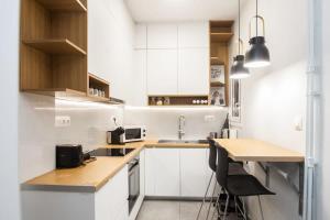 a kitchen with white cabinets and a wooden counter top at Brand new apt in Zografou in Athens