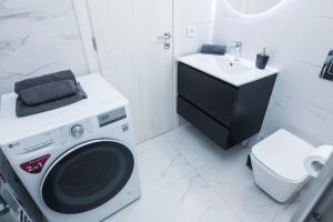 a bathroom with a washing machine and a sink at Brand new apt in Zografou in Athens