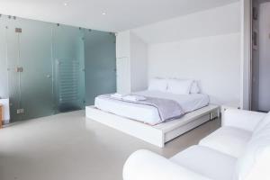 a white bedroom with a bed and two white chairs at Penthouse with 360 View of Athens and Private Gym in Athens