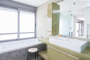 ein Badezimmer mit einem Waschbecken und einem großen Fenster in der Unterkunft Penthouse with 360 View of Athens and Private Gym in Athen