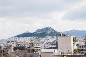 Blick auf eine Stadt mit einem Berg im Hintergrund in der Unterkunft Penthouse with 360 View of Athens and Private Gym in Athen