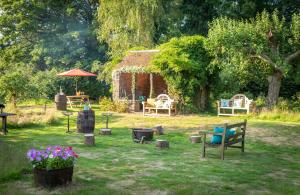 a garden with a gazebo and chairs and flowers at The Mahal a Majestic 4-Bedroom Glamping Palace! in Ross on Wye