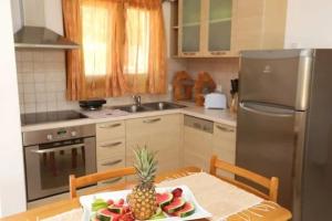 una cocina con una mesa con una piña. en Luxury Villa Nefeli w Private Pool In Skiathos, en Troulos