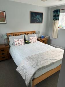 een slaapkamer met een groot bed met kussens bij Ivy Cottage in Stawell