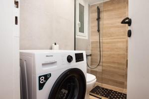 a washing machine in a bathroom next to a toilet at Contemporary Stylish Apartment Located Near Metaxourgeio Area in Athens