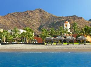 a group of chairs on the beach near the water at Loreto Bay Golf Resort & Spa at Baja in Loreto