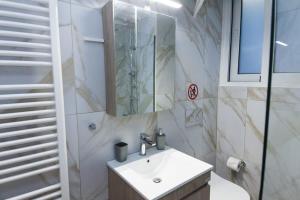 a bathroom with a sink and a mirror at Stylish Brand New Apt near Megaro Mousikis in Athens