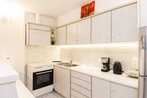 uma cozinha branca com um lavatório e um fogão em Delightful Modern 1 Bedroom Apartment in Kallithea em Atenas