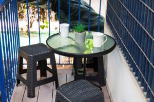 uma mesa e dois bancos numa varanda com uma mesa em Delightful Modern 1 Bedroom Apartment in Kallithea em Atenas