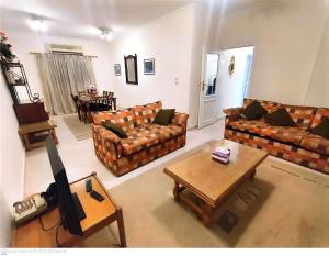sala de estar con sofás, TV y mesa en ابراج المهندسين المعادي كورنيش بجوار مستشفي السلام الدولي, en El Cairo