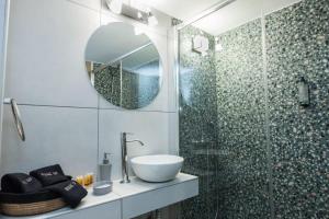 a bathroom with a sink and a glass shower at Metaxourgio 2 Bedroom Gem for Urban Explorers in Athens