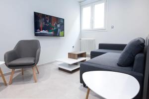 a living room with a couch and a table and chairs at Athenian Comfort 1 Bd Apt Retreat next to Panormou in Athens