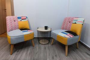 duas cadeiras e uma mesa num quarto em Metaxourgio 2 Bedroom Gem for Urban Explorers em Atenas