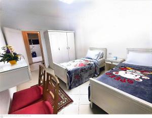 Habitación con 2 camas y una silla. en ابراج المهندسين المعادي كورنيش بجوار مستشفي السلام الدولي, en El Cairo