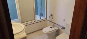 La salle de bains est pourvue de toilettes blanches et d'un lavabo. dans l'établissement Casa Manoli, à Malaga