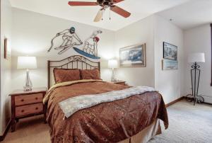 ブリッケンリッジにある2BR Main St Station Ski In Out Condo All Amenitiesのベッドと天井扇風機のある寝室