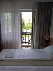 Schlafzimmer mit einem Bett und Blick auf einen Balkon in der Unterkunft Apartment Atina in Subotica