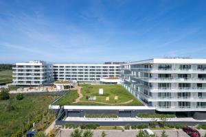 an apartment building with a garden in front of it at Baltini Premium Apartament Polanki Aqua in Kołobrzeg