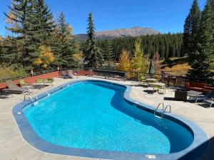 a swimming pool in a resort with mountains in the background at One BDR Ski in Ski Out Condo in Breckenridge