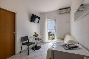 un salon avec un canapé, une table et une fenêtre dans l'établissement Mediterano Apartments, à Podstrana