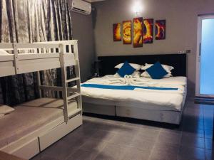 1 Schlafzimmer mit 2 Etagenbetten mit blauen Kissen in der Unterkunft Veyo Retreat in Veymandoo