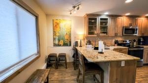 une cuisine avec un îlot doté de chaises et d'une grande fenêtre dans l'établissement Cozy Val dIsere Chalet Steps into Town, à Breckenridge