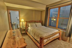 a bedroom with a bed and a table and a window at Corral Hideaway Steps from Downtown in Breckenridge