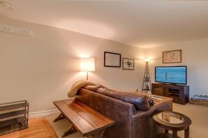 a living room with a leather couch and a television at Cozy Red Roost Residence Essential Getaway in Breckenridge