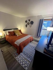 Schlafzimmer mit einem Bett, einem Schreibtisch und einem Fenster in der Unterkunft French Street Retreat Walk Everywhere in Breckenridge