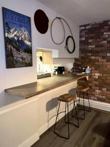 a kitchen with a counter and two bar stools at French Street Retreat Walk Everywhere in Breckenridge
