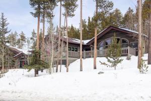 une maison en rondins dans la neige avec des arbres dans l'établissement Spacious Home with Hot Tub, à Breckenridge