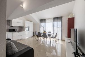 une cuisine et un salon avec une table et des chaises dans l'établissement Mediterano Apartments, à Podstrana
